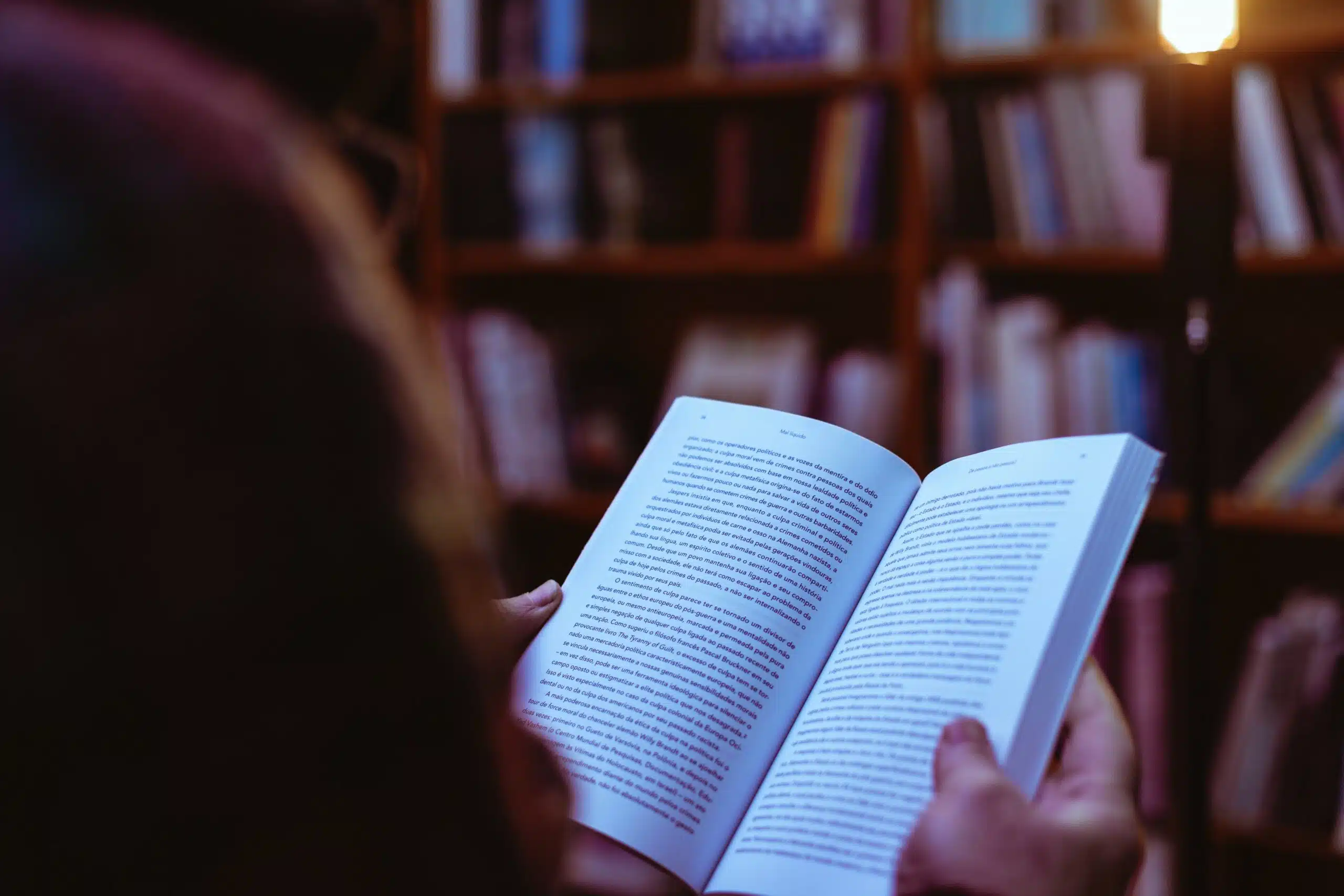 person reading book in library